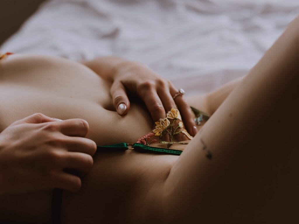 intimate closeup image of a woman at her boudoir session wearing delicate lingerie and her wedding ring